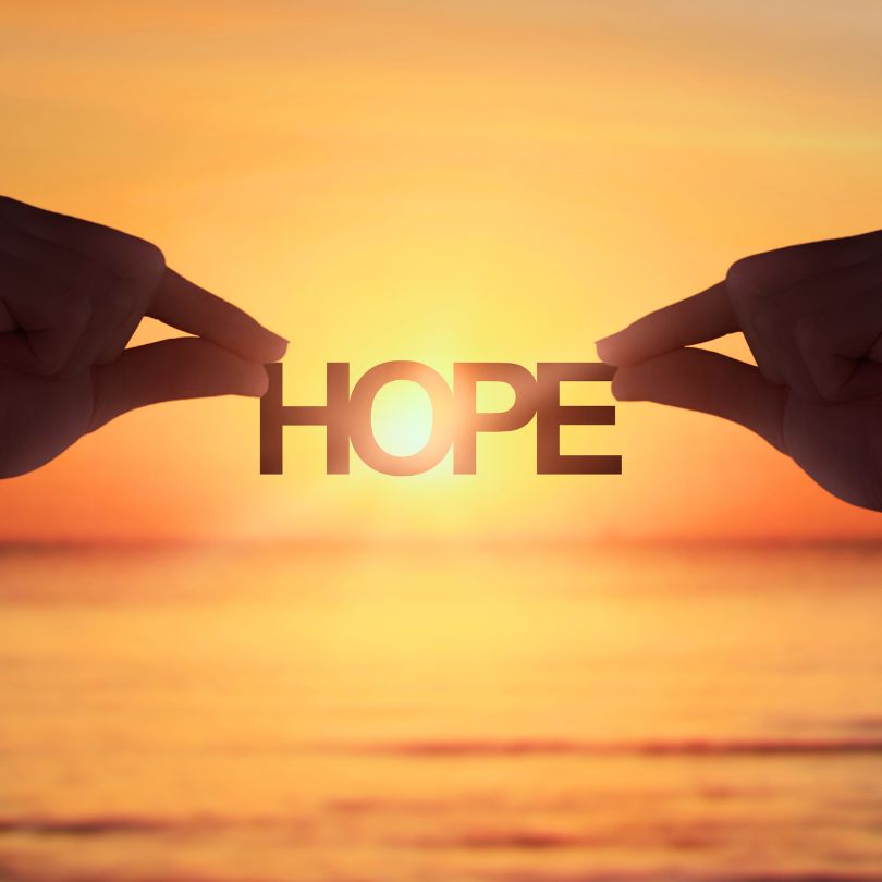 The word "hope" over a beautiful sunset