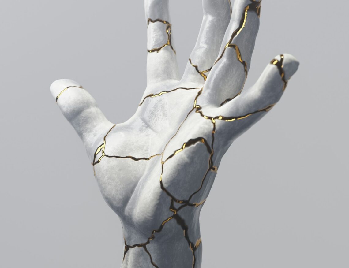 statue of a hand with golden cracks in it